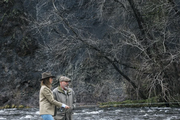 two people standing by river